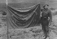 Солдат румынских горных частей с захваченным советским знаменем в поле на Кавказе 1942.jpg