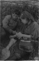 1. Санинструктор К.Я. Данилова перевязывает раненого партизана, июнь 1943.jpg